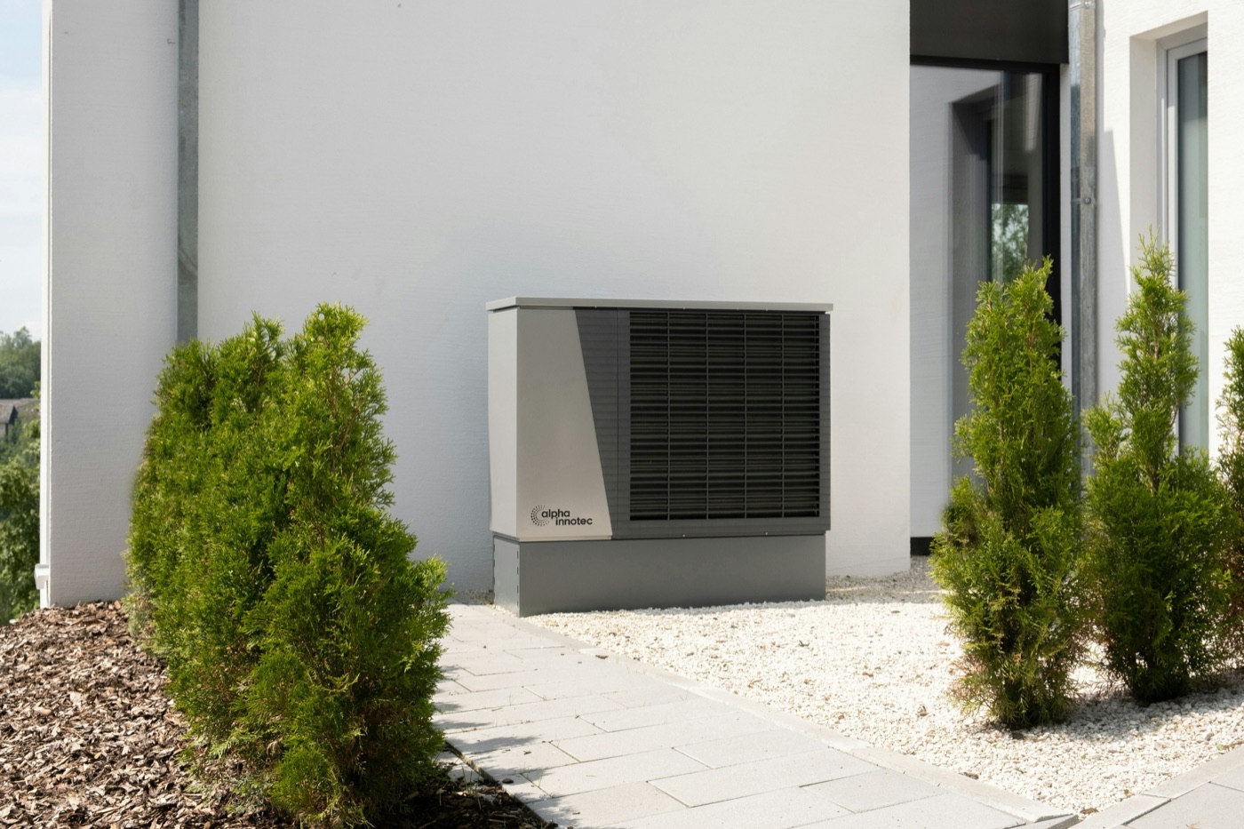 Wärmepumpe vor einem Wohnhaus – Symbolbild für die KfW-Förderung 2026