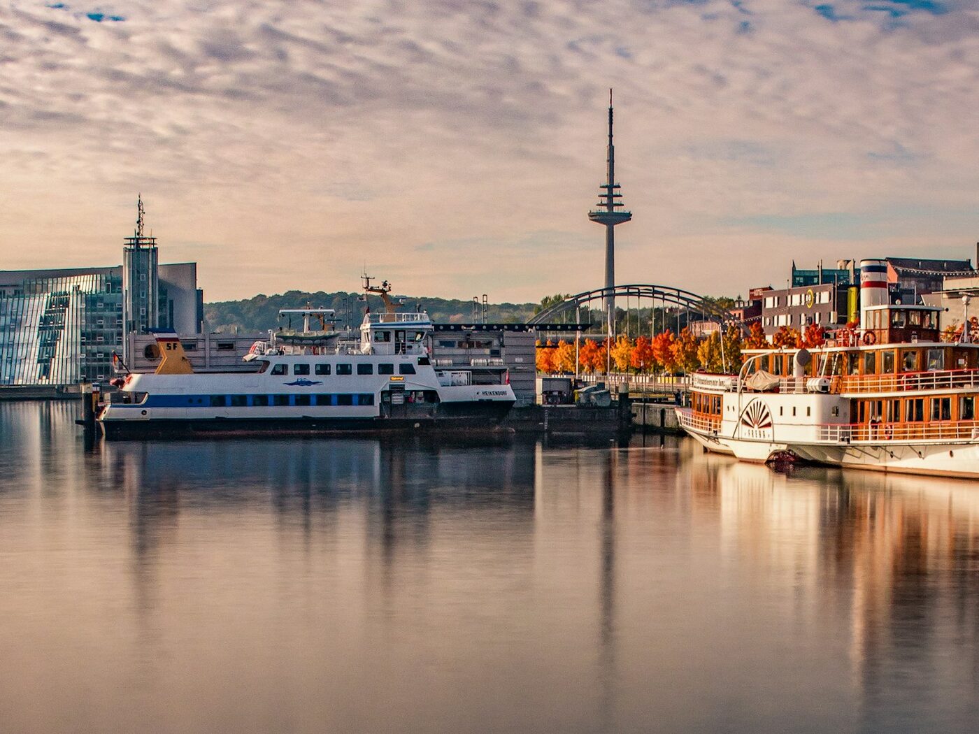 Kieler Hafen an der Förde mit Fähre, Raddampfer und dem Fernmeldeturm im Herbstlicht